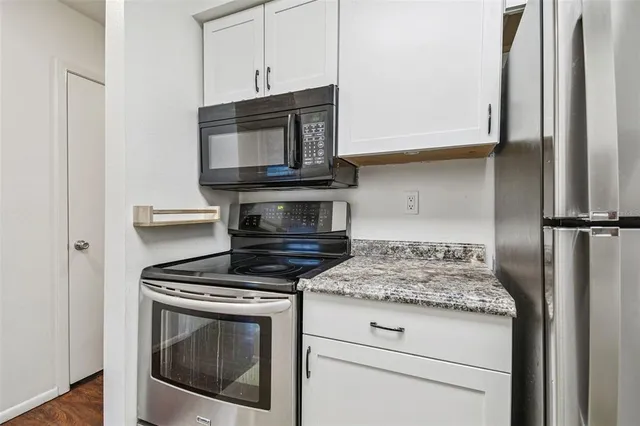 a bathroom with a granite countertop sink a toilet and a large mirror