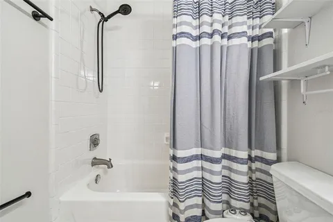 a bathroom with a sink a toilet a mirror and shower curtain