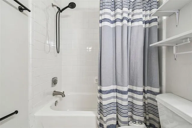 a bathroom with a sink a toilet a mirror and shower curtain