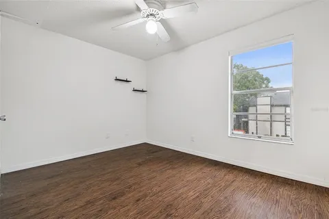 a walk in closet with wooden floor