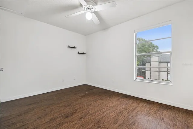 a walk in closet with wooden floor
