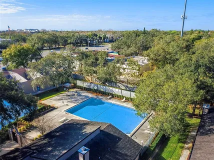 an aerial view of residential houses with outdoor space and trees
