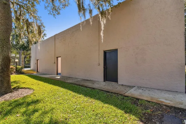 a view of a swimming pool with a bench and trees around
