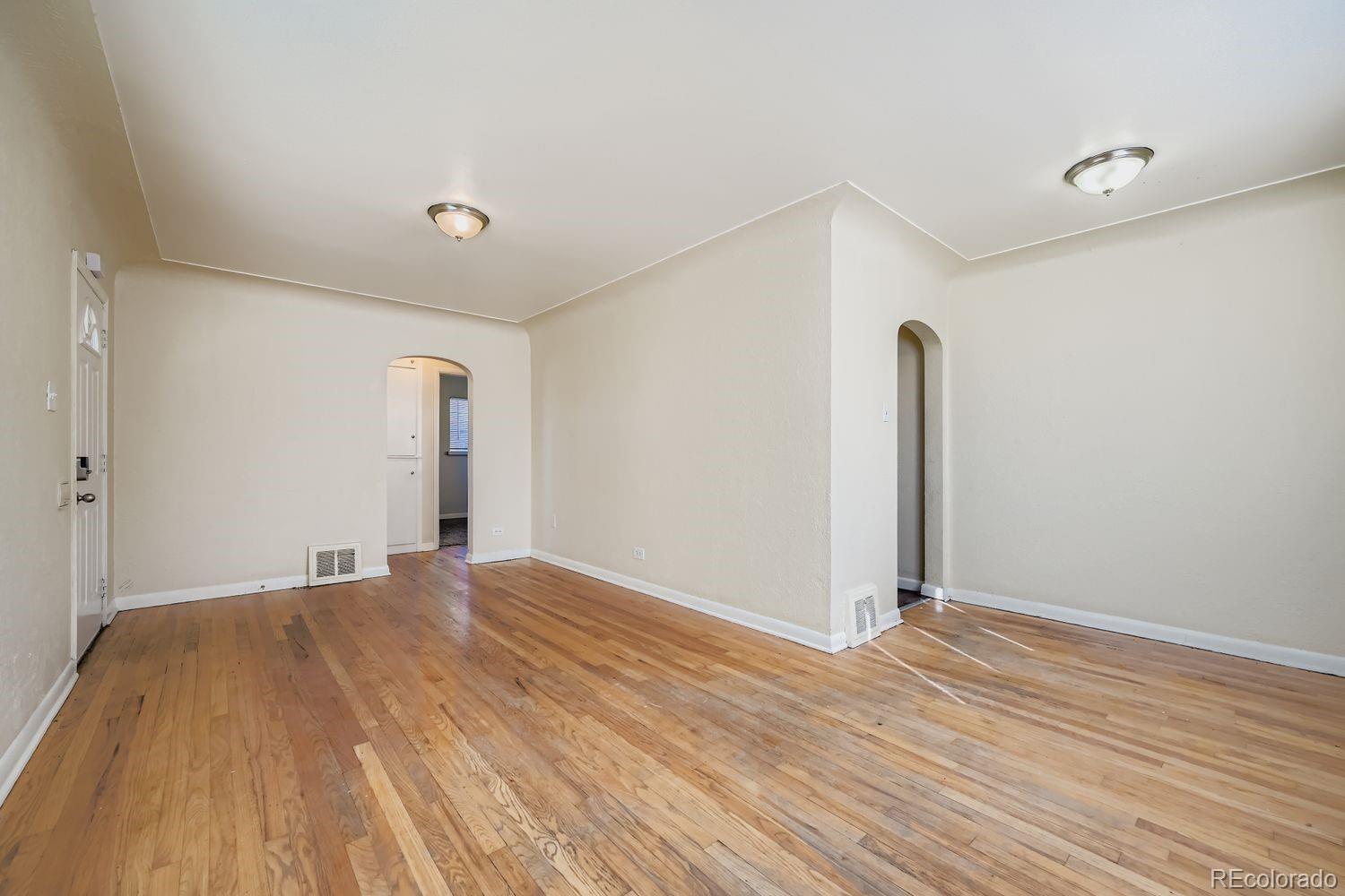 3690 Magnolia Street Denver, CO 80207 - Photo 3 of 17 a view of an empty room with wooden floor