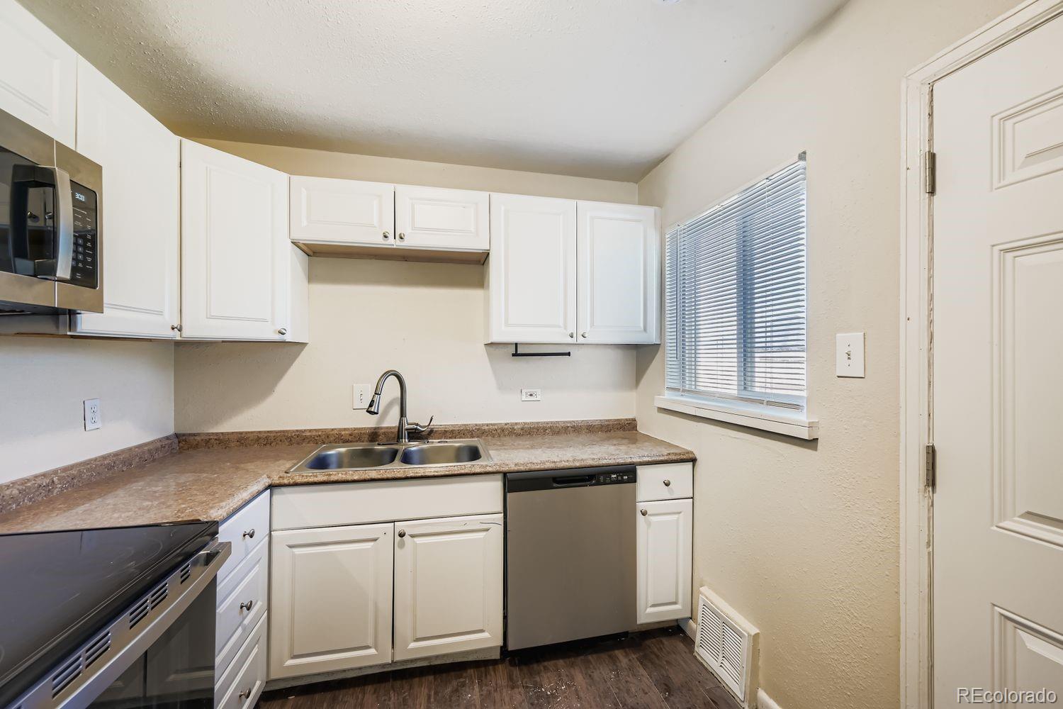3690 Magnolia Street Denver, CO 80207 - Photo 4 of 17 a kitchen with granite countertop white cabinets and a sink