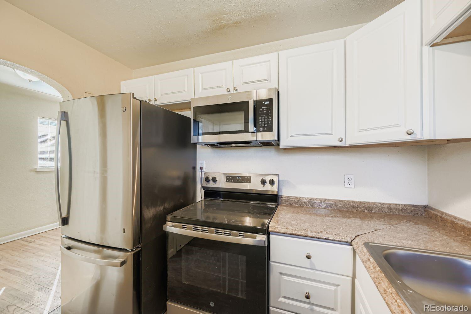3690 Magnolia Street Denver, CO 80207 - Photo 5 of 17 a kitchen with stainless steel appliances granite countertop a refrigerator stove and sink