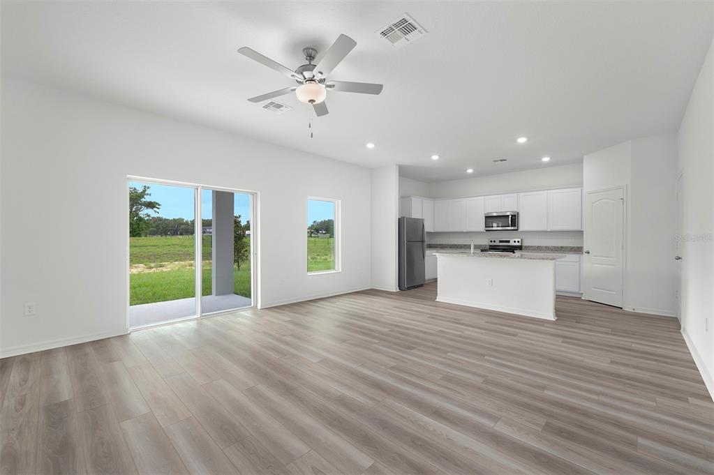 13291 Tula Loop Astatula, FL 34705 - Photo 3 of 22 a view of an empty room with kitchen and window