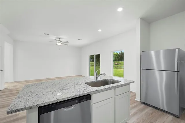 a kitchen with stainless steel appliances granite countertop a refrigerator and a sink