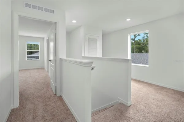 a view of a hallway with closet and bathroom