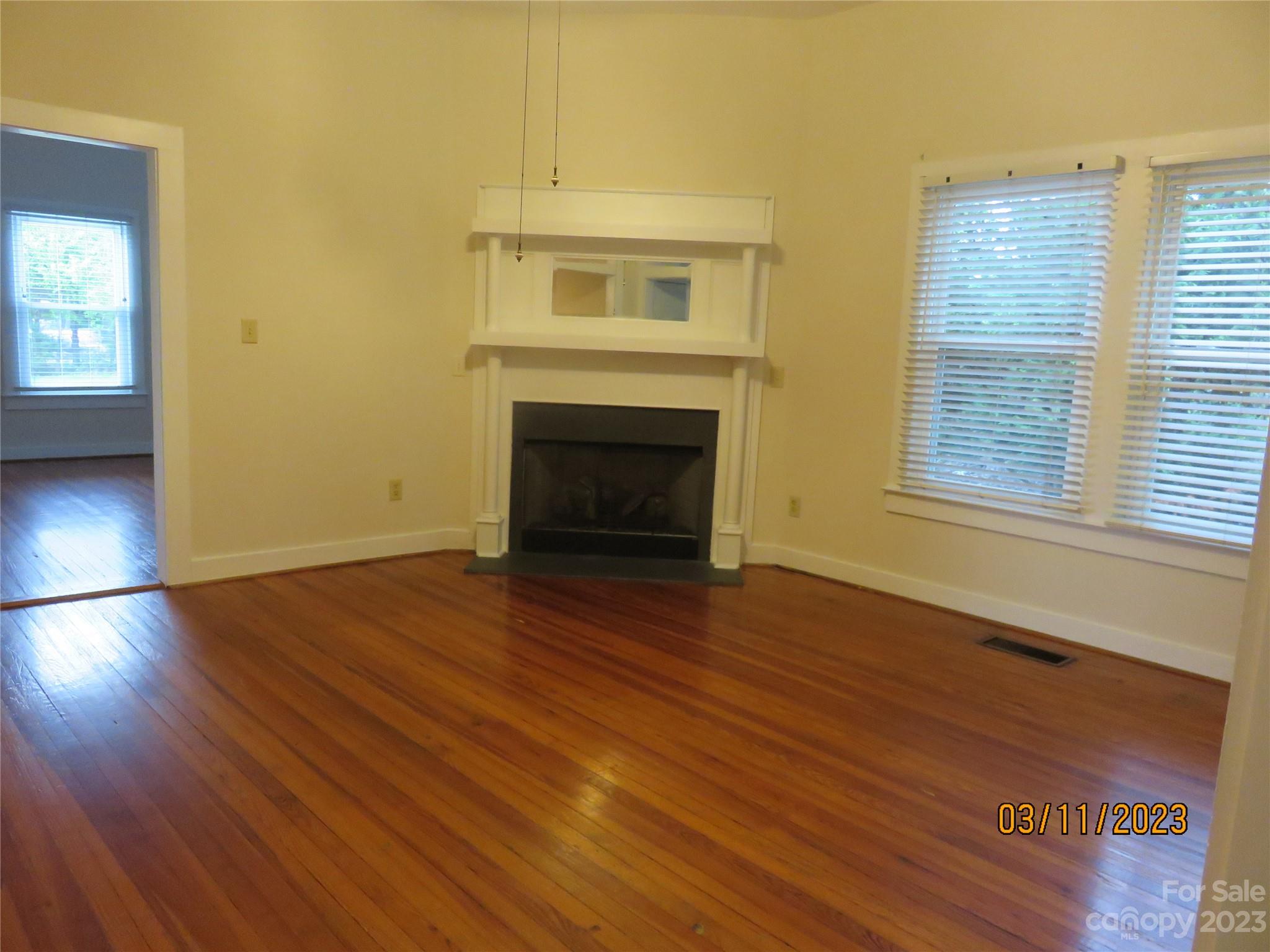 514 Marvin Road Indian Land, SC 29707 - Photo 6 of 40 an empty room with wooden floor fireplace and windows