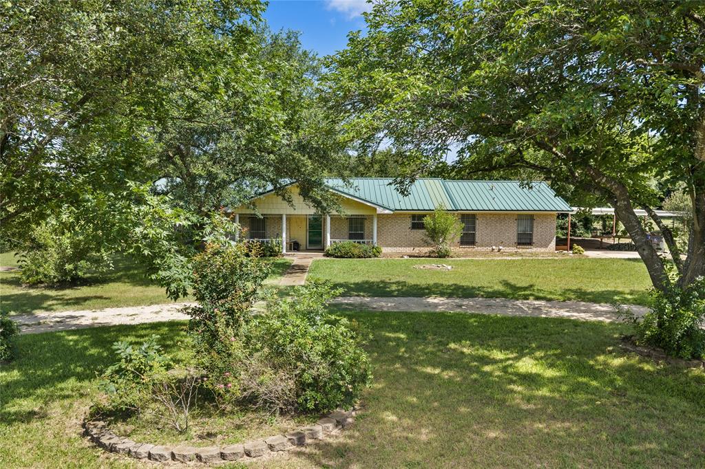 440 Williams Road Lorena, TX 76655 - Photo 6 of 19 Ranch-style residence featuring a green metal roof, light brick exterior, and a covered front porch