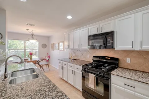 a kitchen with a stove a sink and a microwave