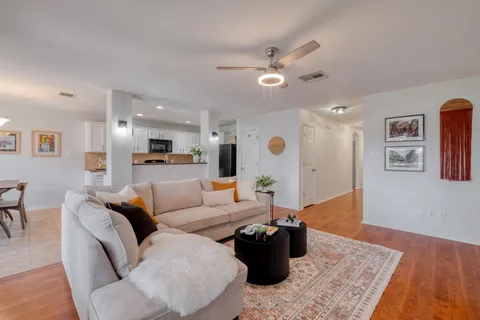 a living room with furniture and a wooden floor