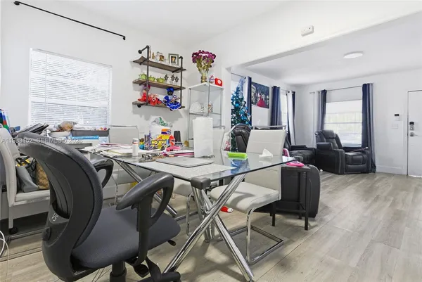 a view of a dining room with furniture a chandelier and wooden floor
