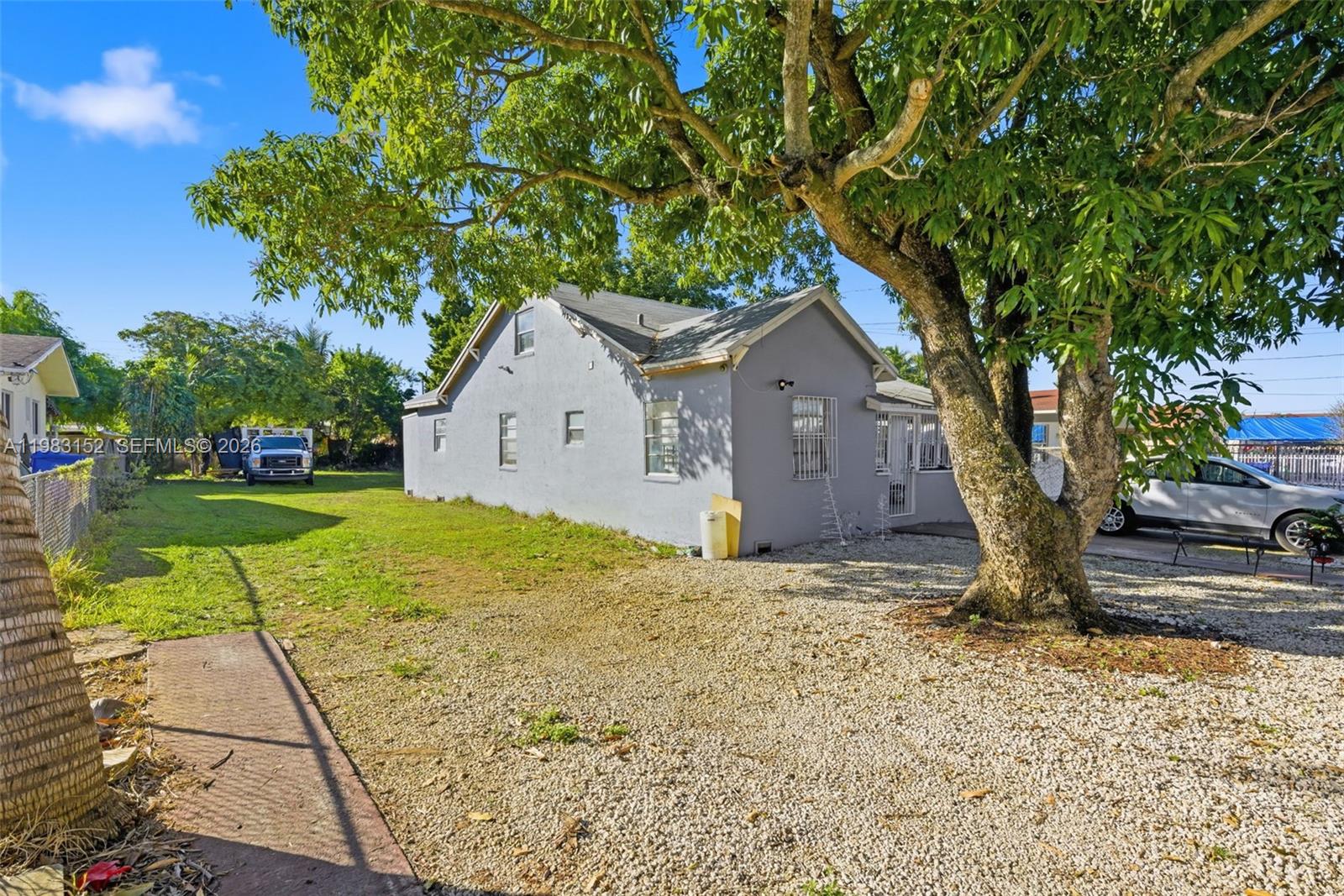 2142 Northwest 33rd Street Miami, FL 33142 - Photo 2 of 26 a house with a tree in front of it