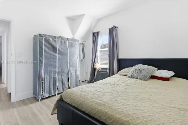 a bedroom with a bed and wooden floor