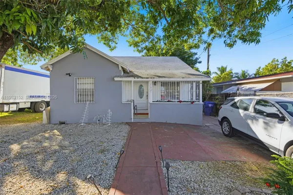 a view of a house with a yard and sitting area