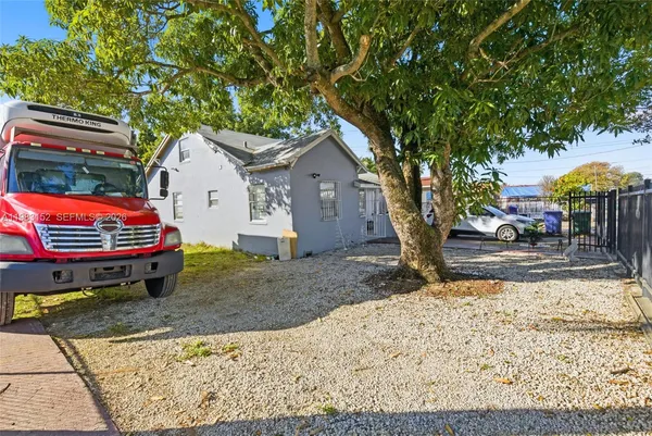 a backyard of a house with barbeque oven fire pit table and chairs
