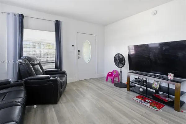 a living room with furniture flat screen tv and a window