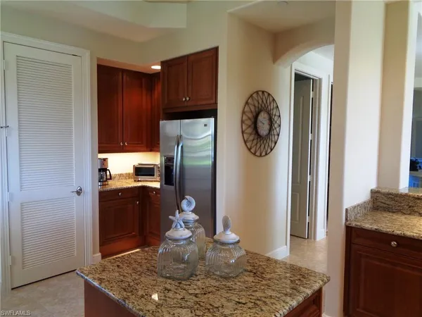 a kitchen with stainless steel appliances granite countertop a refrigerator a stove and a sink