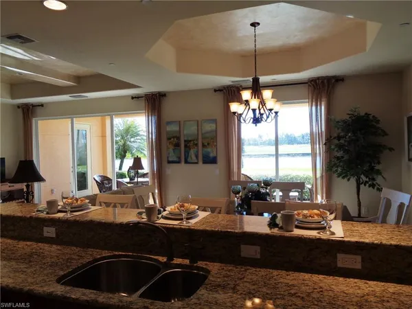 a kitchen with granite countertop a stove and a view of dining room