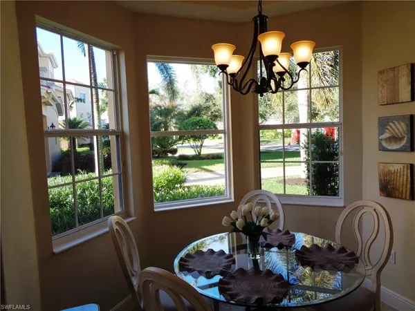 a dining room with furniture large windows and a chandelier