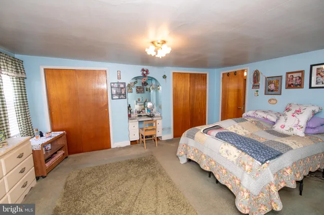 a bedroom with a bed and a painting on the wall