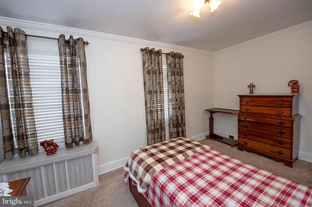 a bedroom with a bed and a lamp next to a window