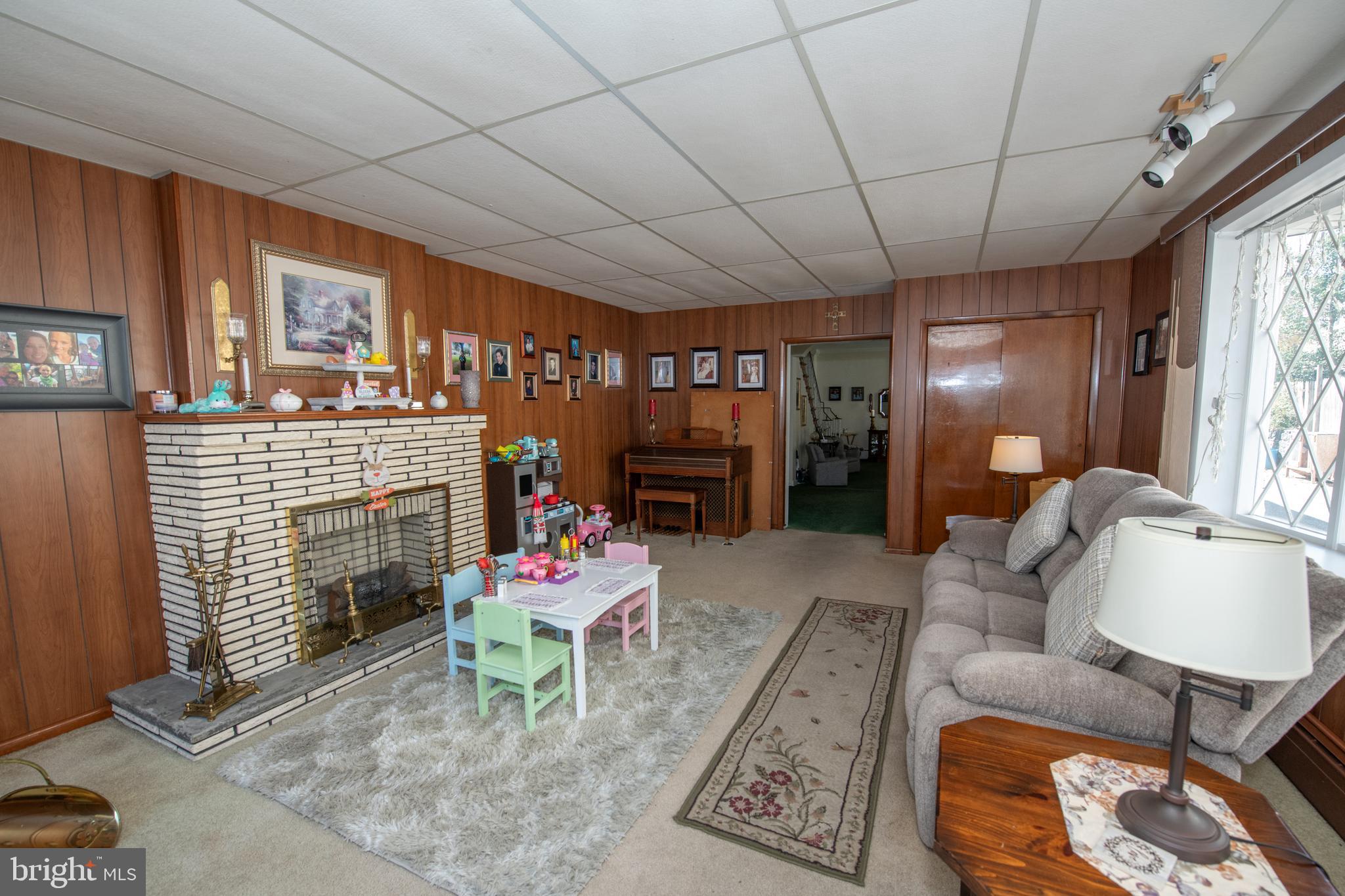 2740 Pratt Street Philadelphia, PA 19137 - Photo 7 of 45 a living room with furniture a fireplace and a floor to ceiling window