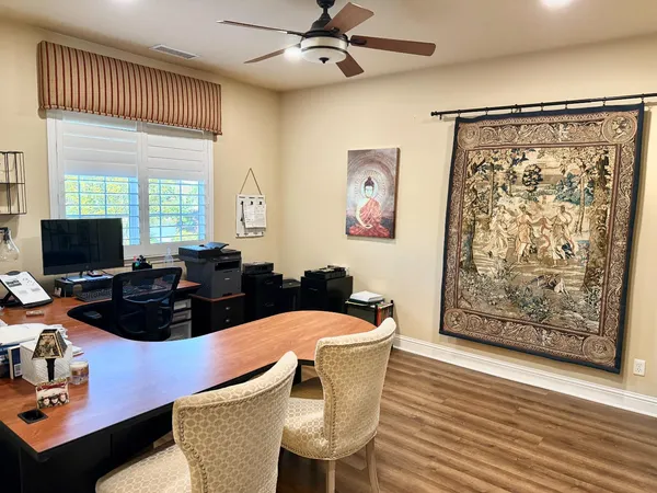a view of a workspace with furniture and wooden floor