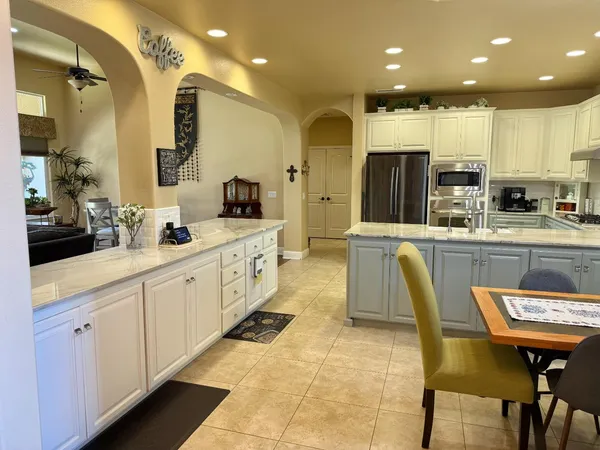 a large kitchen with stainless steel appliances kitchen island granite countertop a sink and cabinets