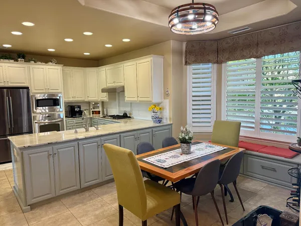 a kitchen with a dining table chairs sink and refrigerator