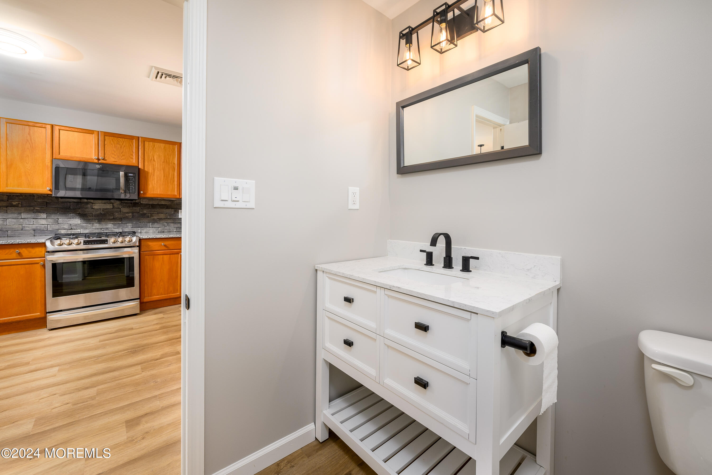 554 Lillie Road Toms River, NJ 08753 - Photo 17 of 26 a bathroom with a sink a mirror and a toilet
