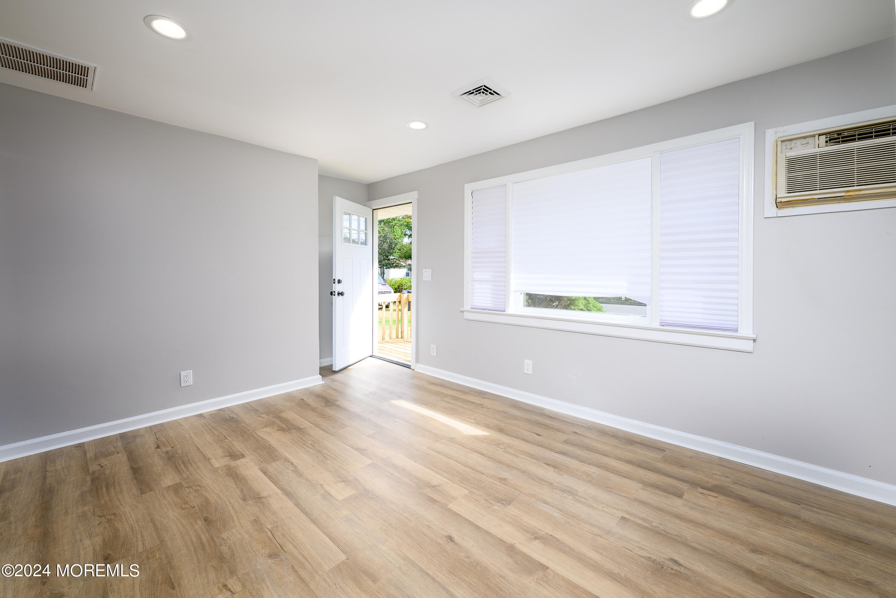 554 Lillie Road Toms River, NJ 08753 - Photo 4 of 26 a view of an empty room with wooden floor and a window
