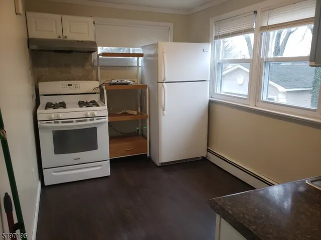 a kitchen with a stove top oven and refrigerator