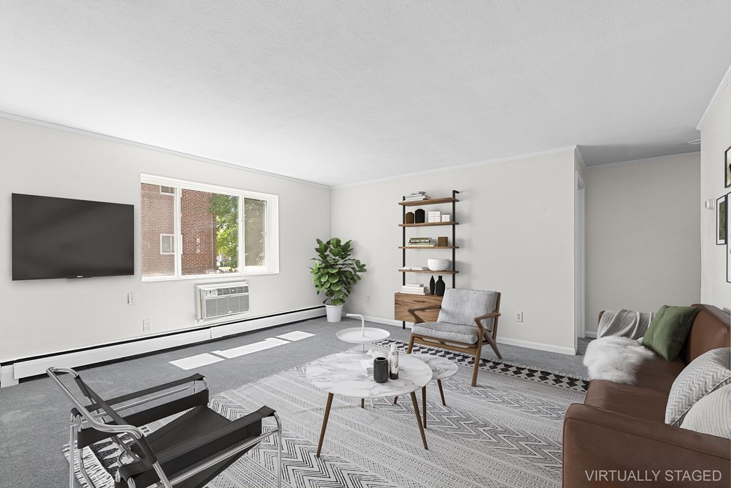 a living room with furniture a flat screen tv and a window