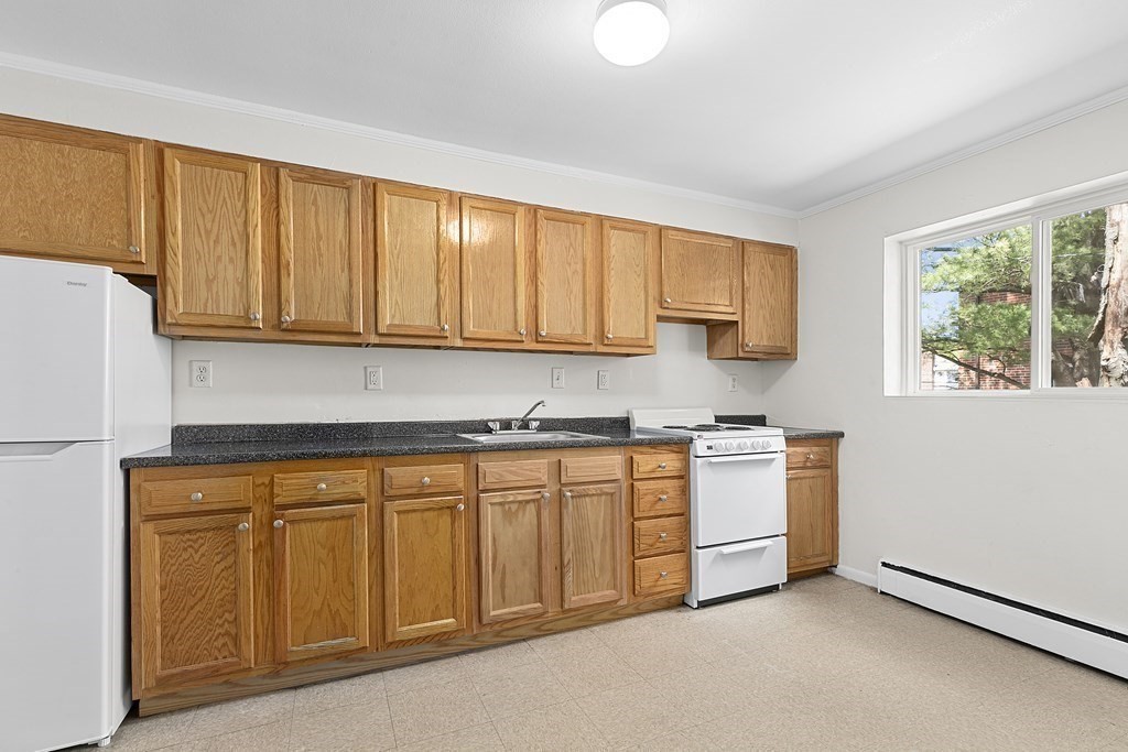 50 Bryon Road, Unit 3 Boston, MA 02467 - Photo 3 of 8 a kitchen with granite countertop white cabinets and sink