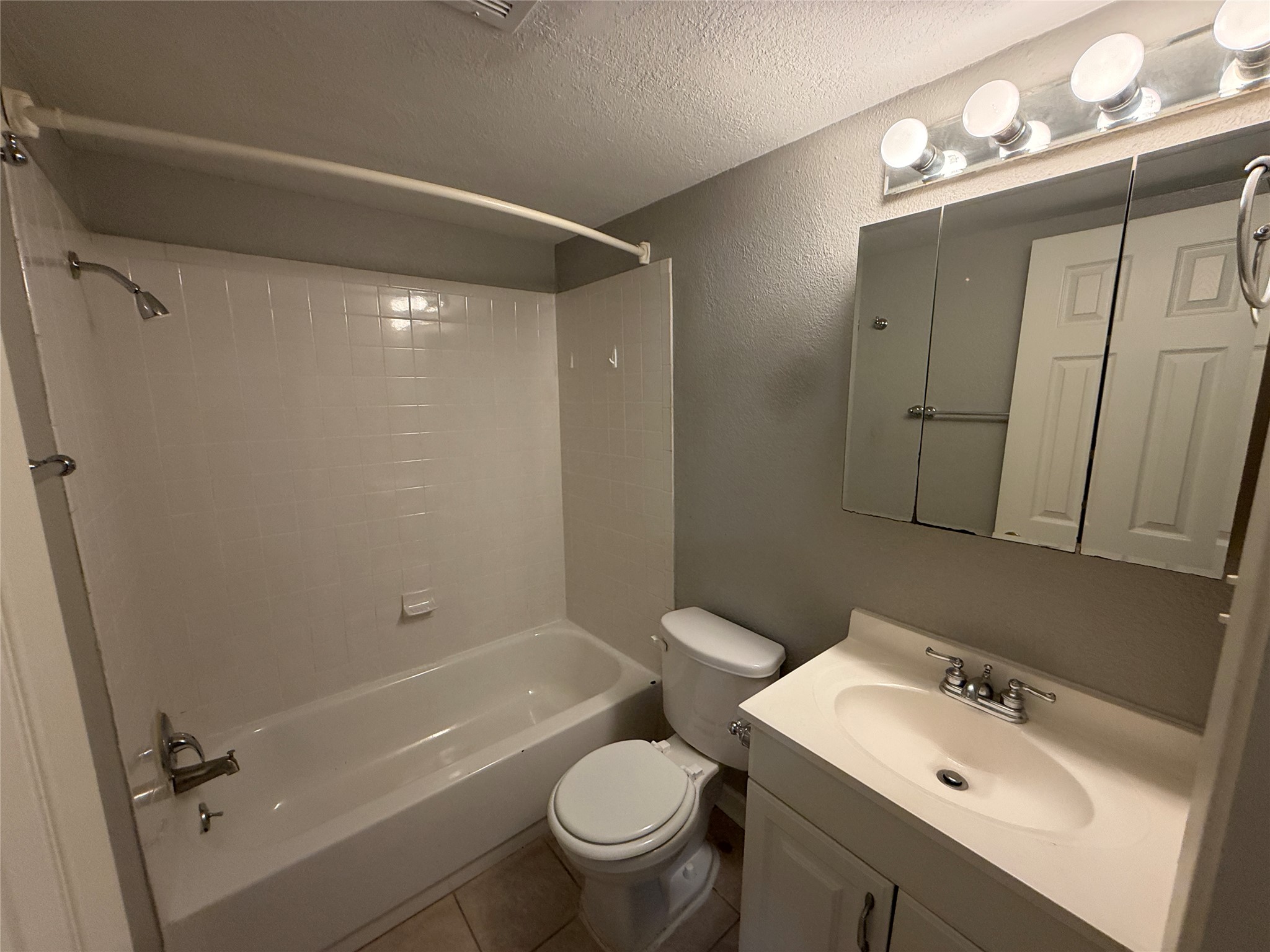 2500 Burleson Road, Unit 209 Austin, TX 78741 - Photo 6 of 15 A classic tiled shower tub combination anchors this functional bathroom space.