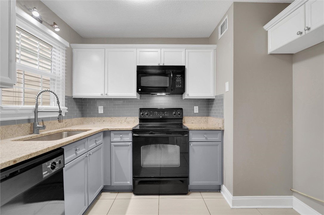 123 Trailside Lane Greenville, SC 29607 - Photo 12 of 29 This modern kitchen features light-toned granite countertops and a sleek tile backsplash.