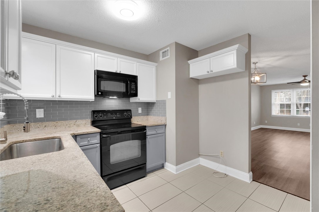 123 Trailside Lane Greenville, SC 29607 - Photo 13 of 29 This modern kitchen features sleek countertops, stylish cabinetry, and durable tile flooring, perfect for daily living.