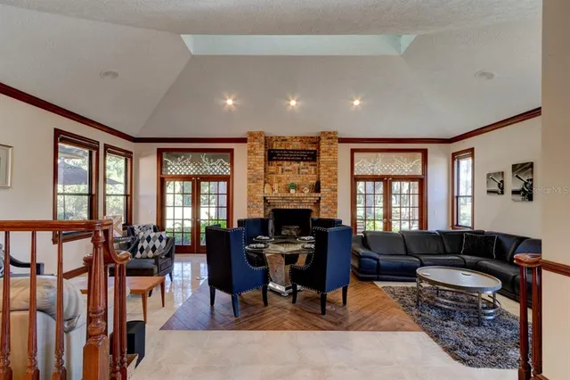 a living room with furniture a flat screen tv and large windows