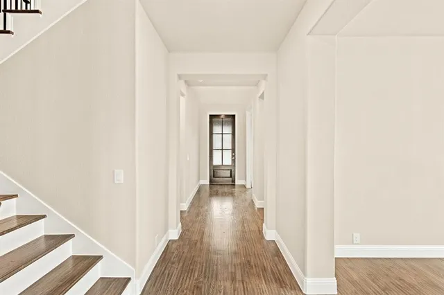 a view of a hallway with wooden floor