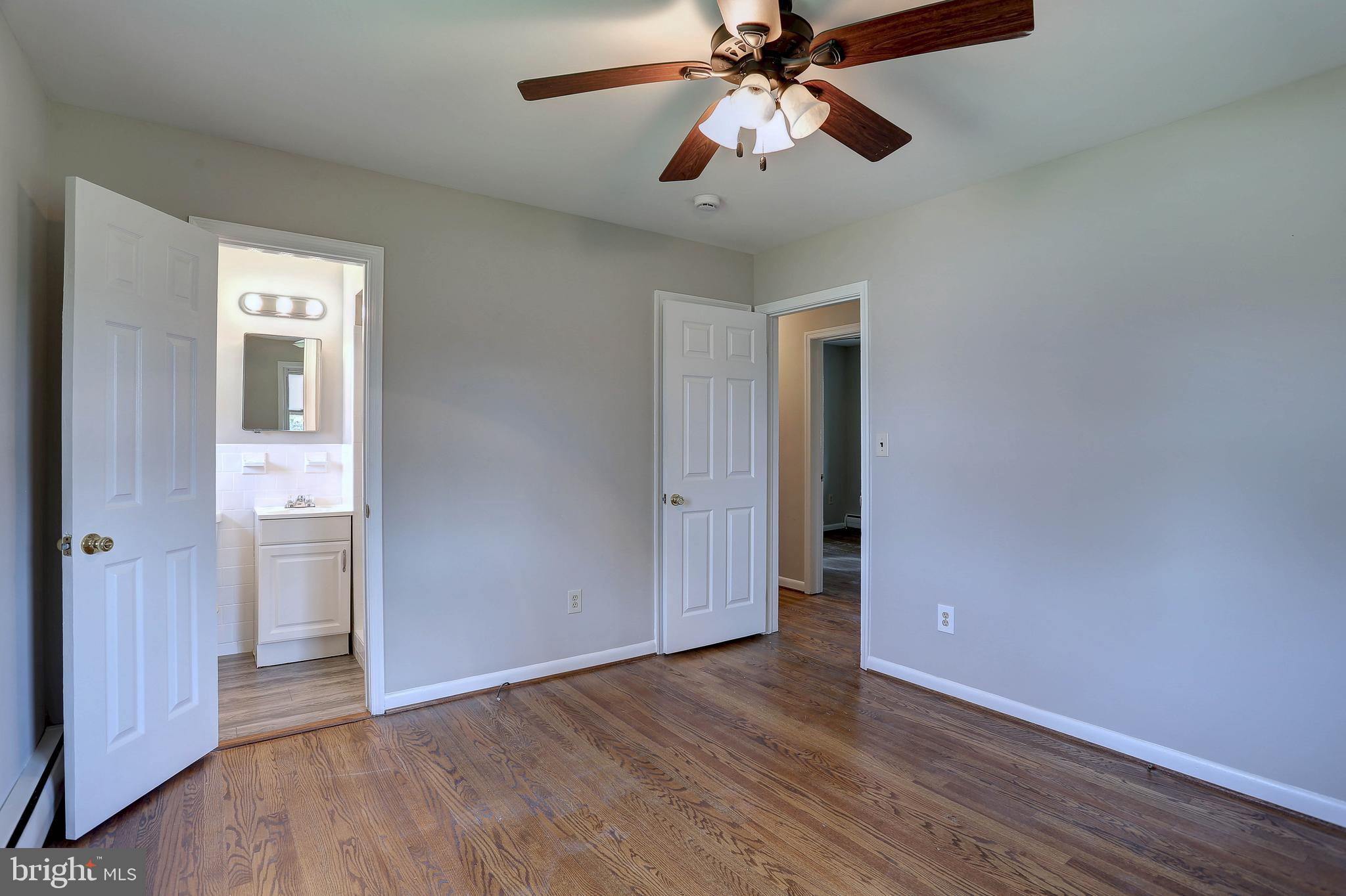 10355 Scaggsville Road Laurel, MD 20723 - Photo 20 of 41 an empty room with wooden floor a chandelier fan and closet area