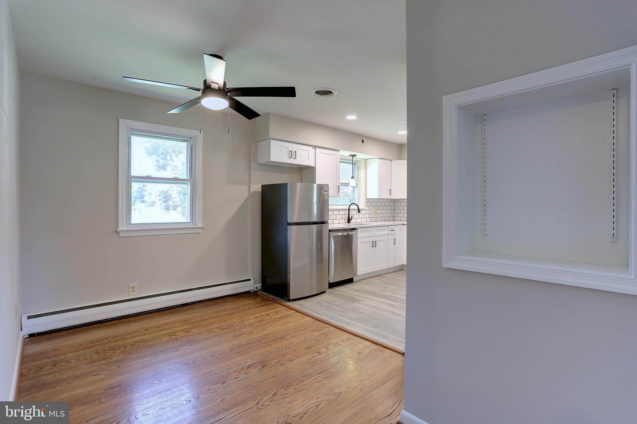 10355 Scaggsville Road Laurel, MD 20723 - Photo 7 of 41 a view of a kitchen with wooden floor a sink a refrigerator and window