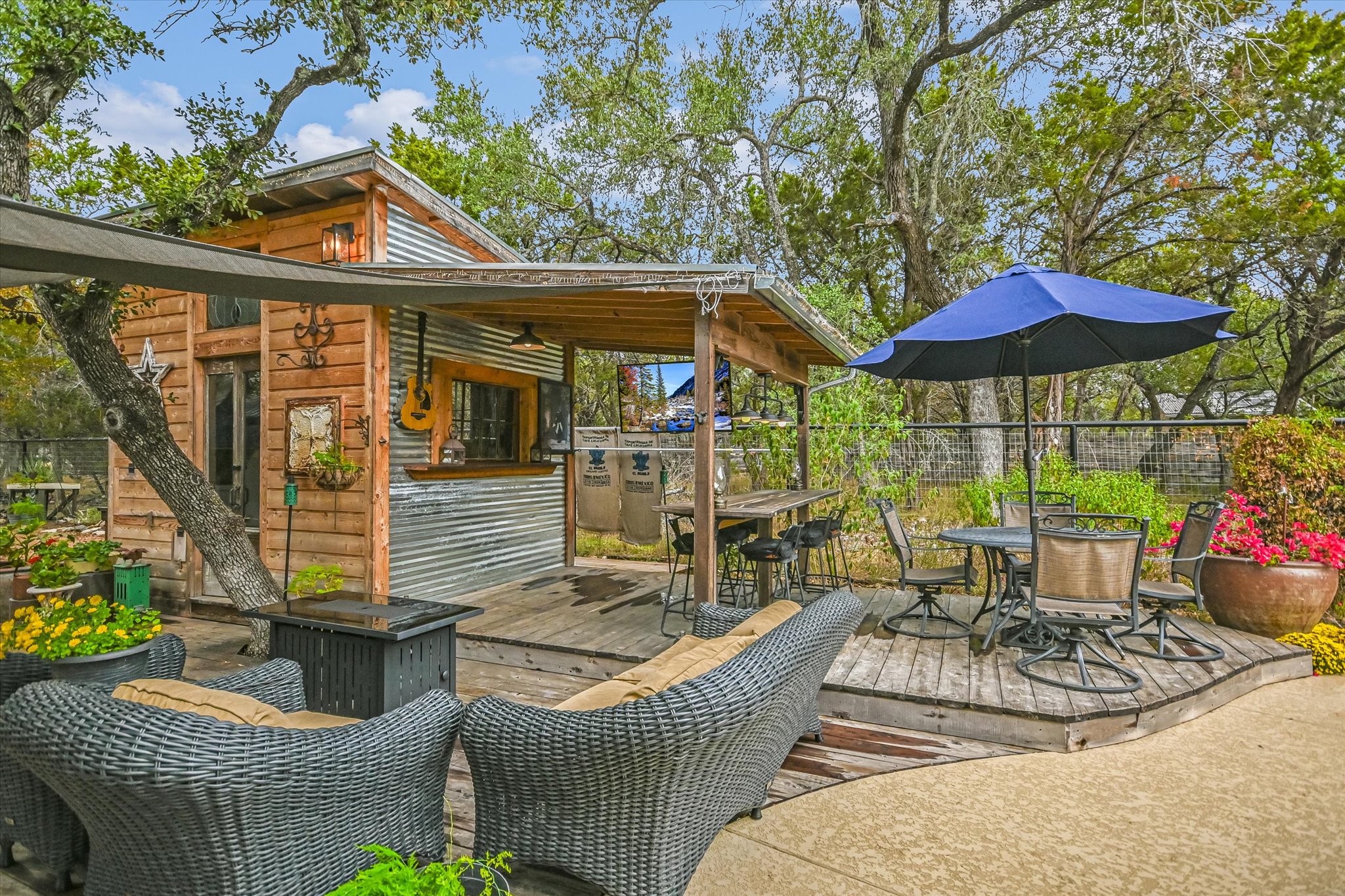 5 Sumac Court Wimberley, TX 78676 - Photo 21 of 26 a view of a patio with couches chairs under an umbrella with a fire pit
