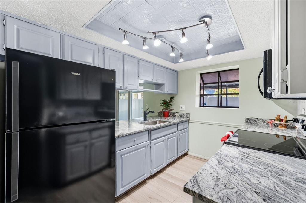 10187 122nd Avenue Largo, FL 33773 - Photo 11 of 48 a kitchen with stainless steel appliances kitchen island granite countertop a refrigerator stove top oven and sink