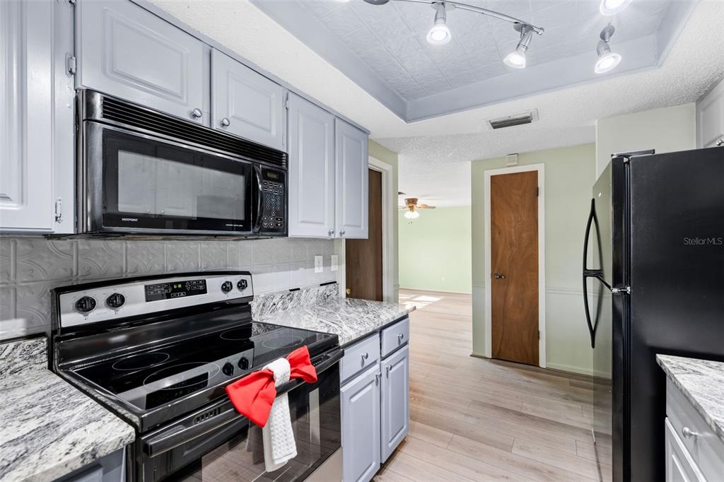 10187 122nd Avenue Largo, FL 33773 - Photo 13 of 48 a kitchen with stainless steel appliances kitchen island granite countertop a stove microwave and refrigerator