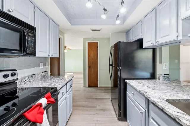a kitchen with stainless steel appliances granite countertop a refrigerator stove and sink