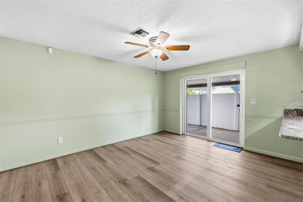 10187 122nd Avenue Largo, FL 33773 - Photo 16 of 48 an empty room with wooden floor chandelier fan and windows