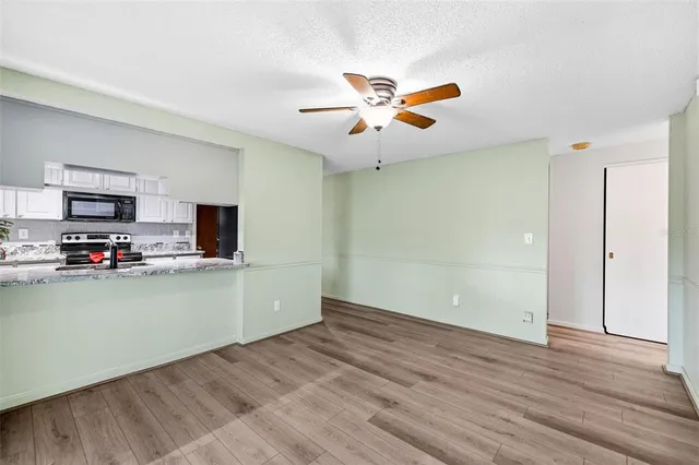 a view of a kitchen with a sink a ceiling fan and hardwood floor